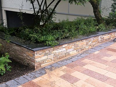 Natursteinmauer mit Abdeckplatte aus Basalt